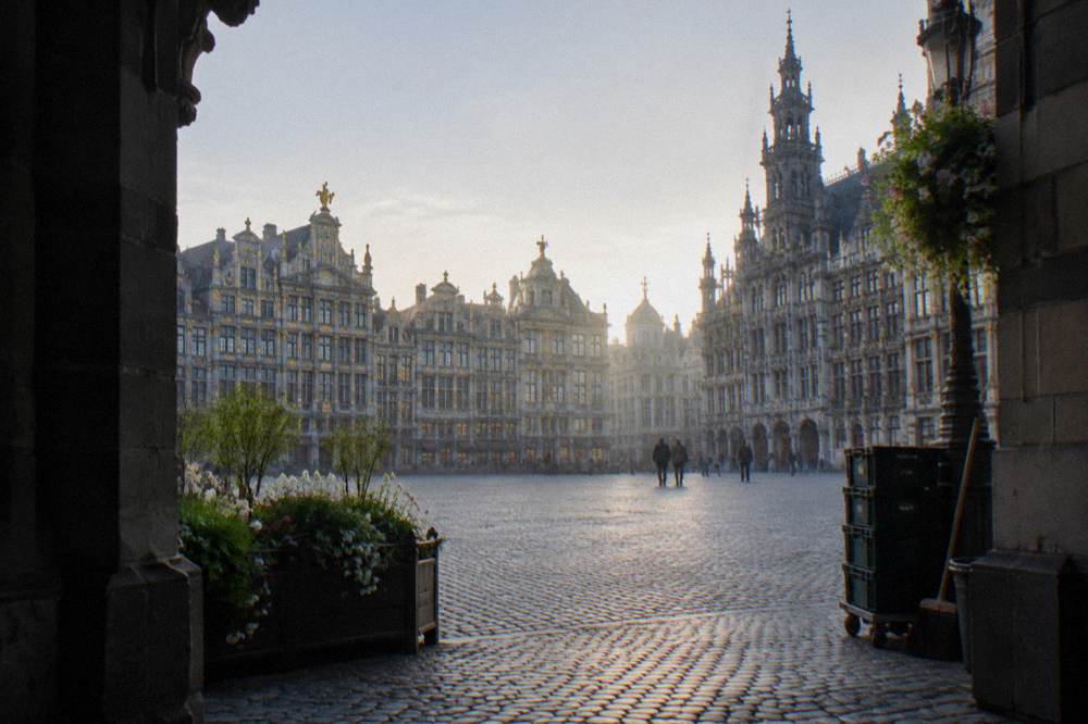 Decorated building facades around a large cobblestone plaza on a bright morning