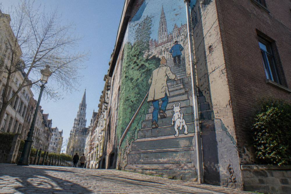 A colourful comic strip mural covering the wall of a tall Brussels building