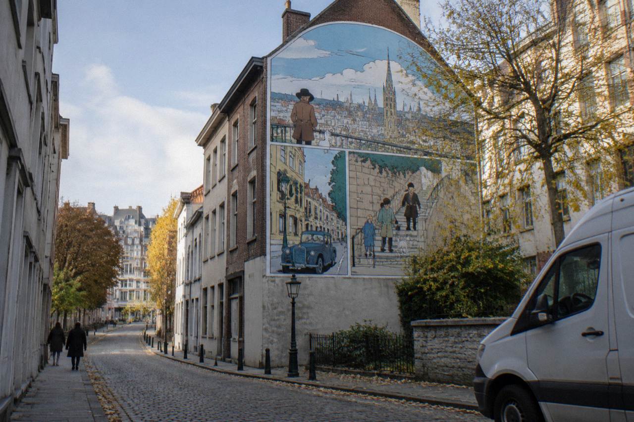 A large comic strip mural painted on the side of a city building in Brussels