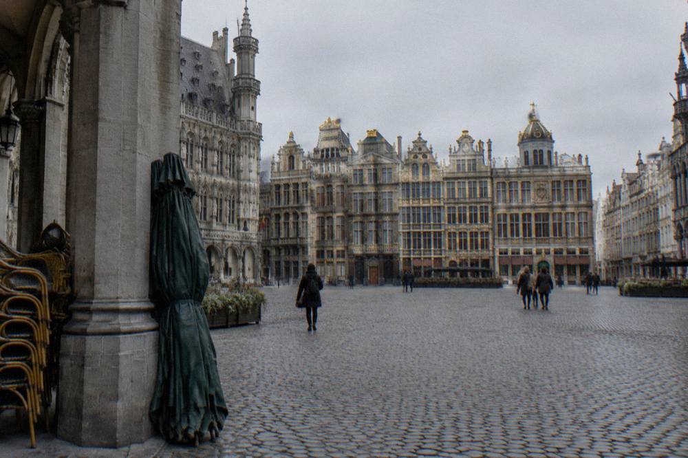 Gilded guild house facades on a historic square under an overcast sky