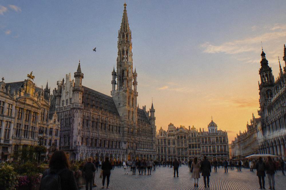 Gothic city hall tower rising above a crowded square at dusk