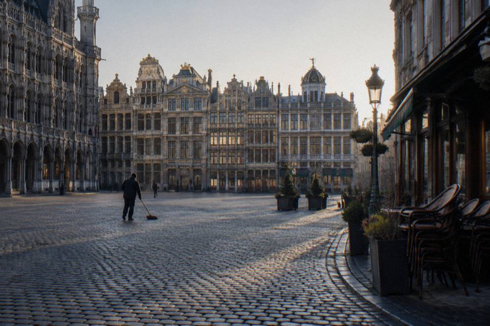Cobbled square in Brussels lined with ornate guildhouses under a clear sky