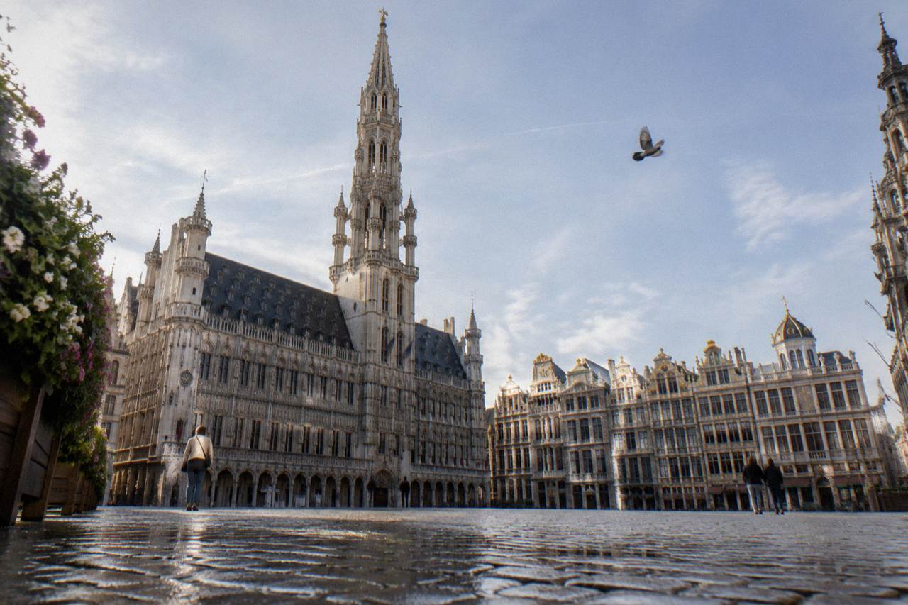 Grand-Place in Brussels with the City Hall tower rising above gilded guildhouses under a bright sky