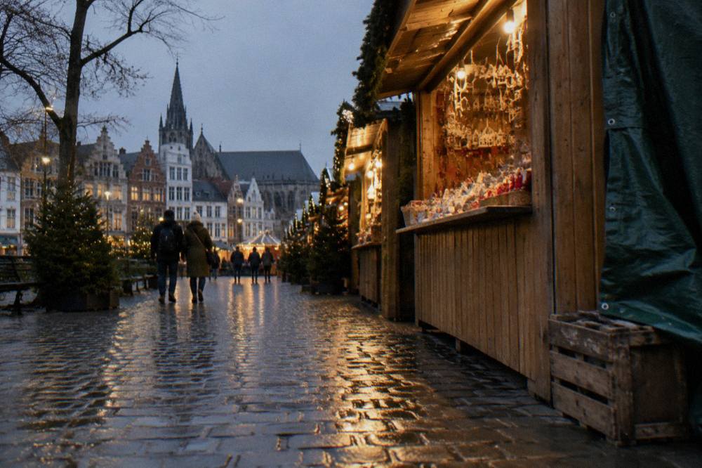 Wooden Christmas market stalls with lights standing on a cobbled square in Brussels