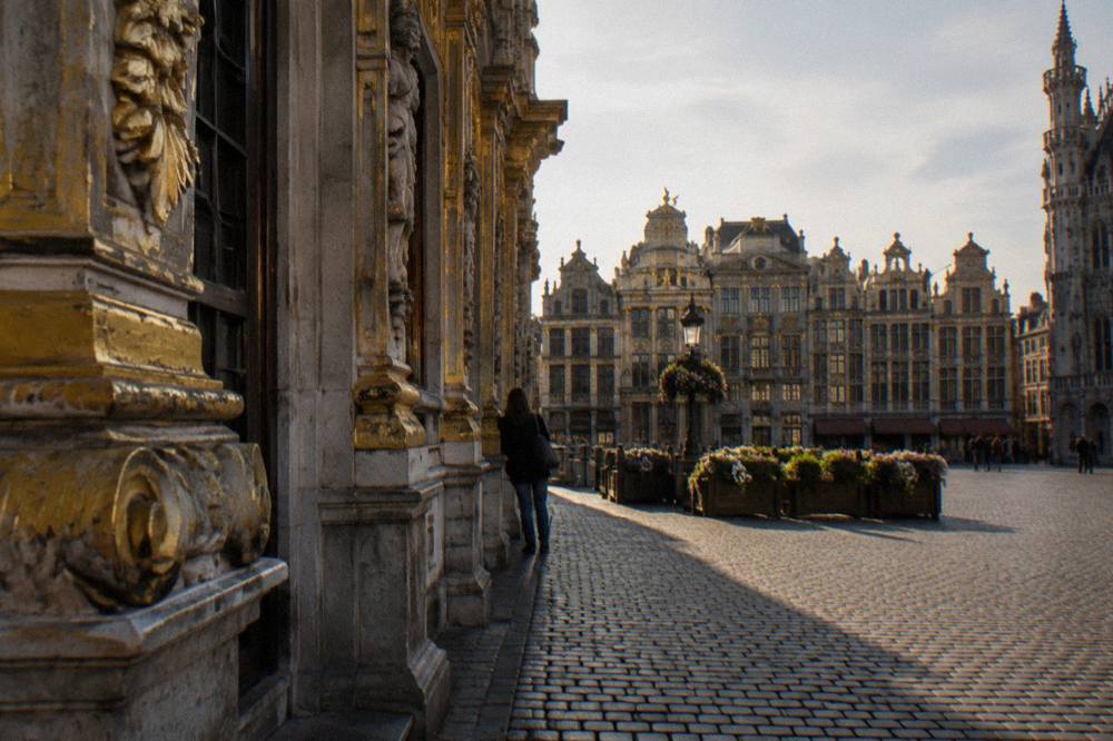 Gilded guildhall facades along the edge of a wide cobblestone square