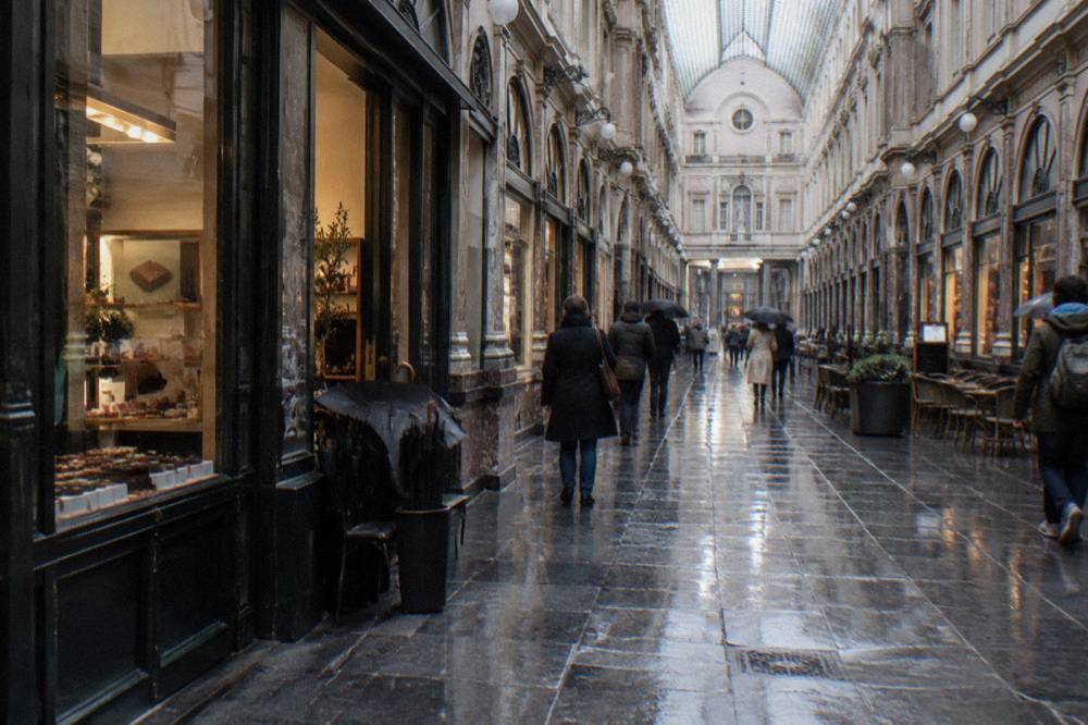 Glass-roofed nineteenth century shopping arcade with storefronts along both sides