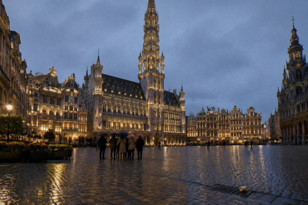 Grand-Place in Brussels lit up at night with the City Hall tower rising above the square