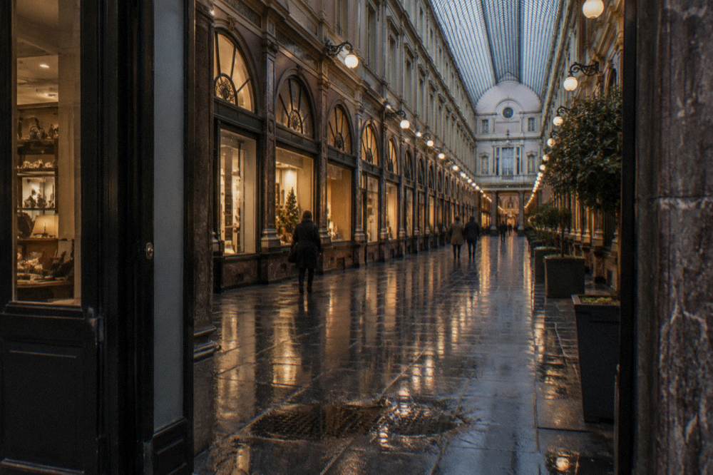 Covered gallery of Galeries Royales Saint-Hubert in Brussels lit in the evening with shopfronts glowing