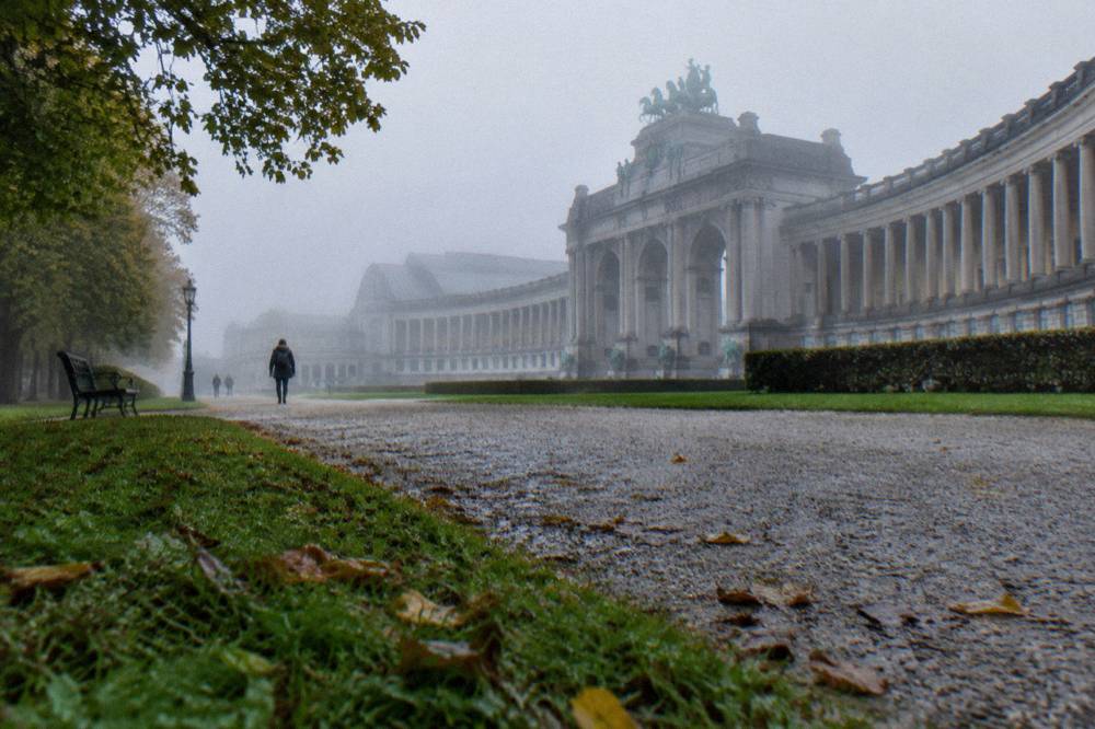 The colonnade of the Cinquantenaire buildings seen from the park lawns in late afternoon light