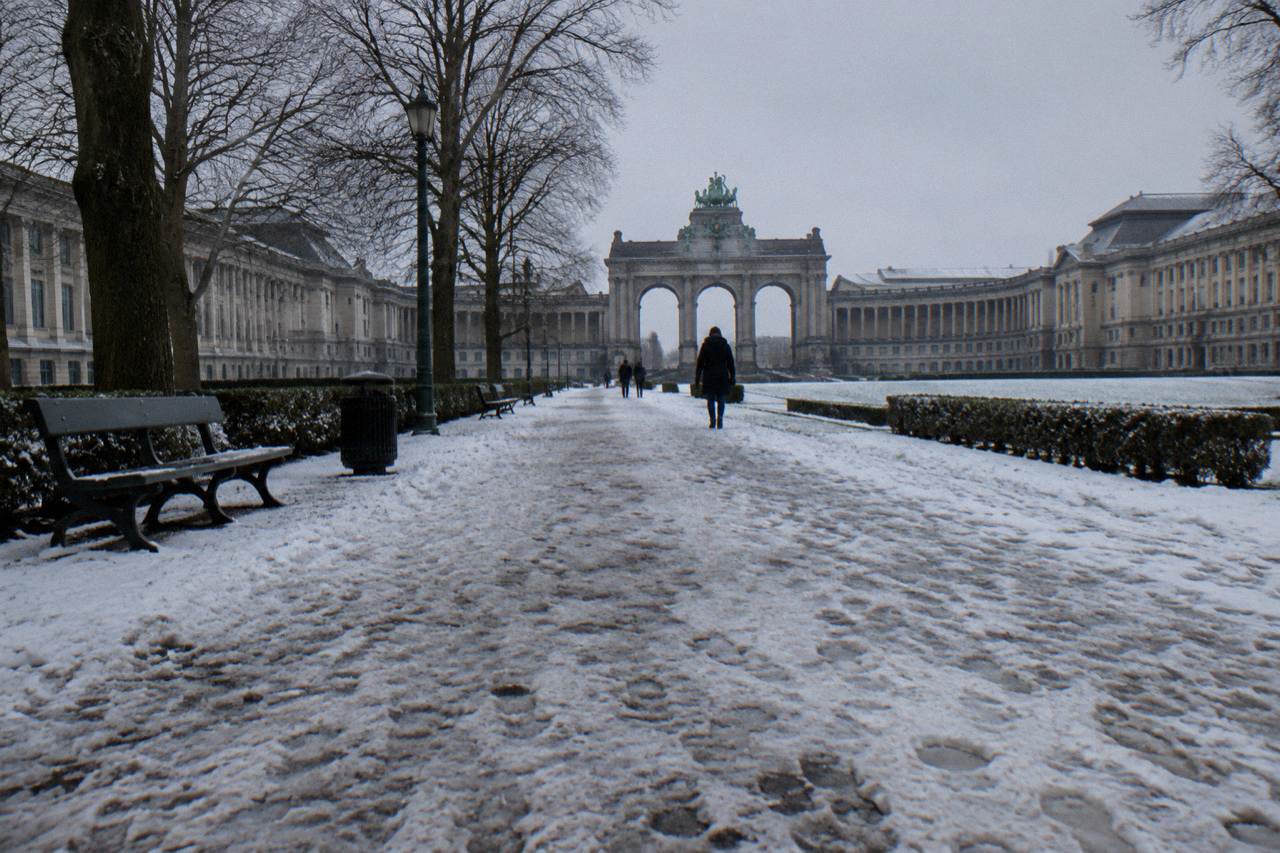 The Cinquantenaire arch and colonnade in Brussels with museum buildings on each side under a daytime sky