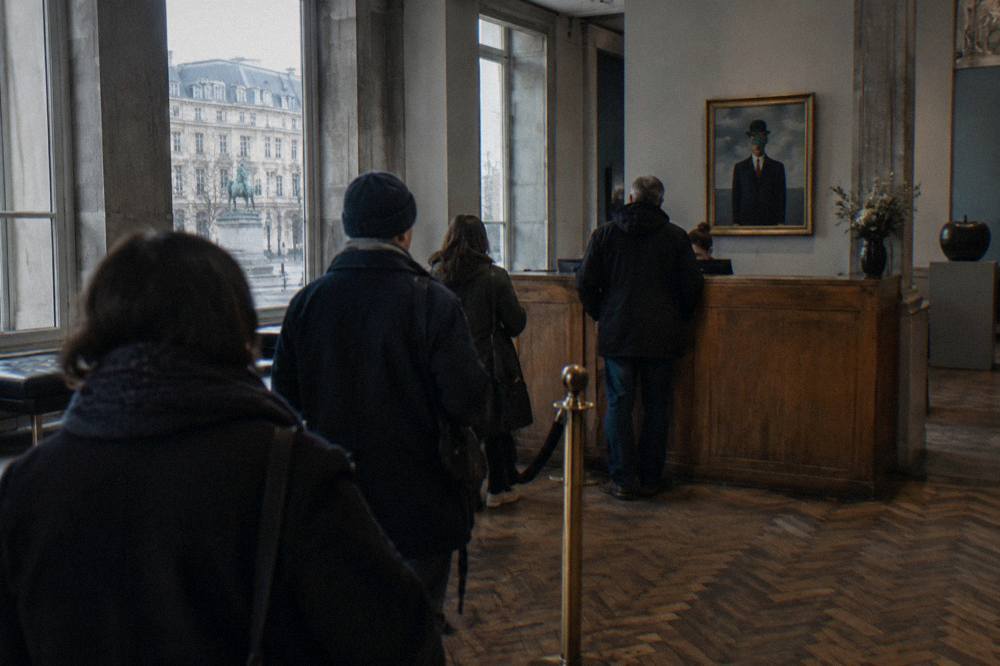 The admission desk area of the Magritte Museum in Brussels with visitors collecting tickets