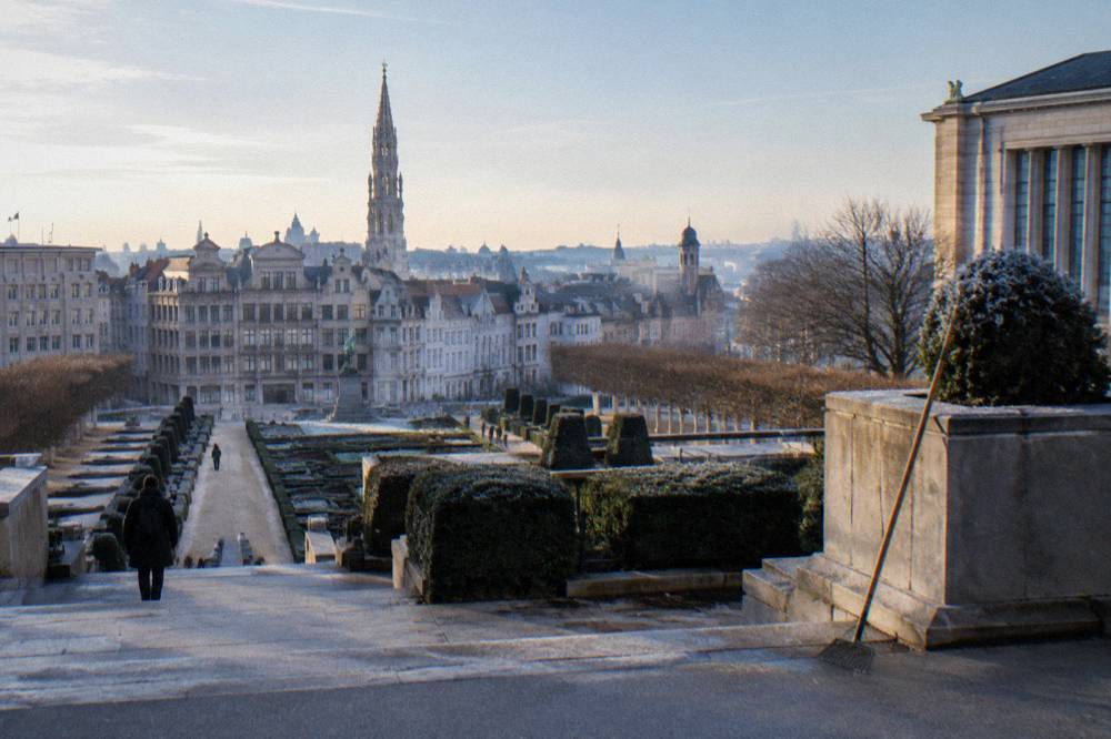 Terraced garden walkway overlooking rooftops and a museum building in Brussels