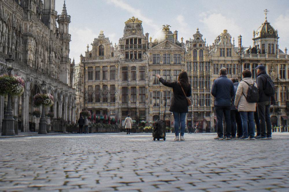 A walking guide speaking to a small group on the Grand-Place square in Brussels