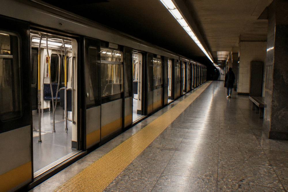 A Brussels metro station platform with a train waiting