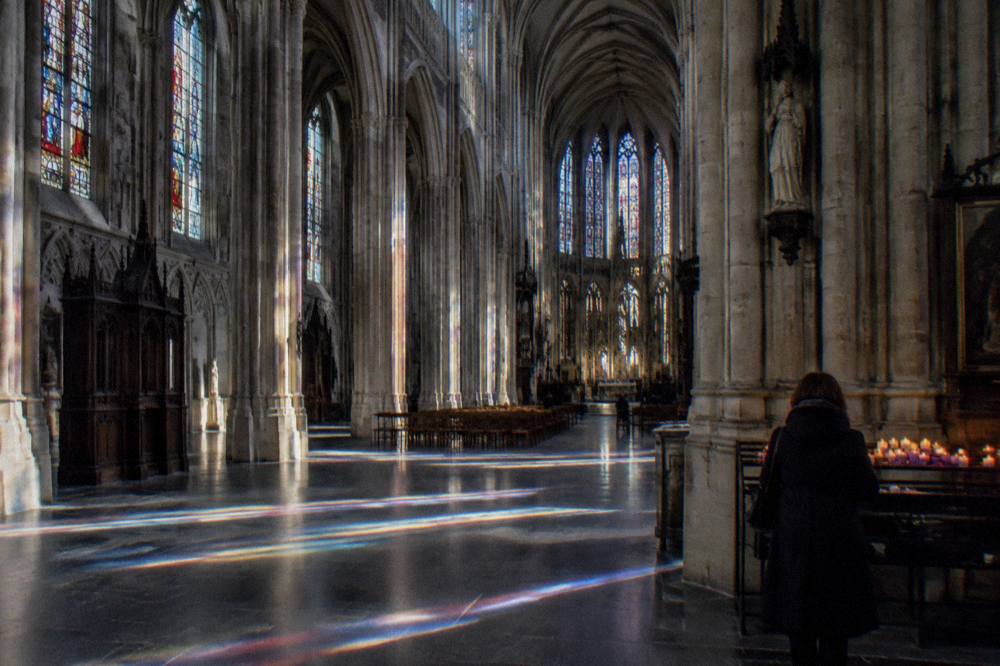 Interior of a Gothic cathedral with a long stone nave and tall arched windows