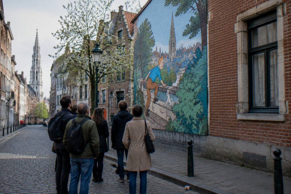 A group of visitors standing in a Brussels square looking up at a building