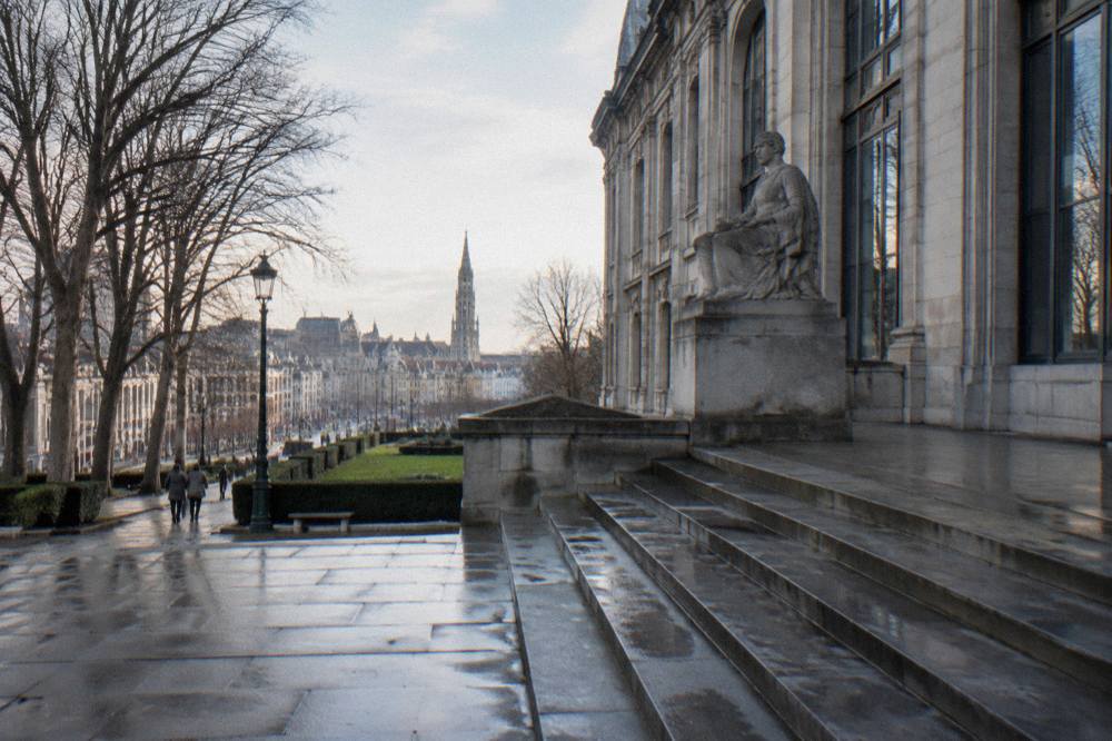 Grand gallery of a Brussels museum with tall windows and winter light on stone floors