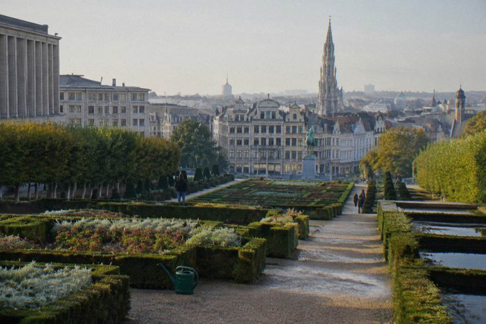 Terraced public garden with clipped hedges overlooking city rooftops
