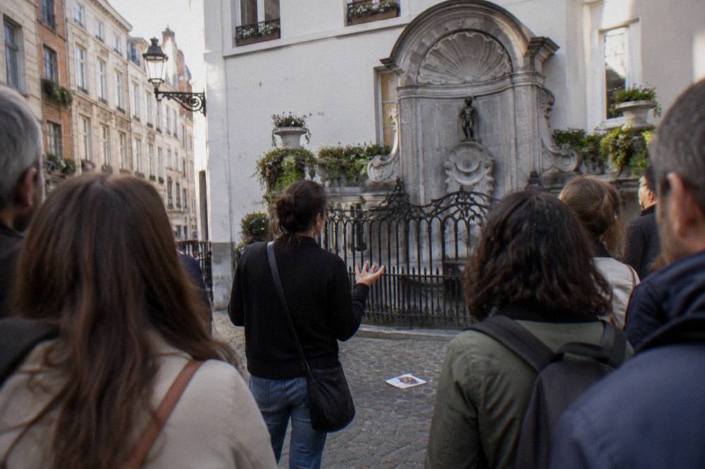 Guide speaking to a group of visitors standing on a cobblestone square