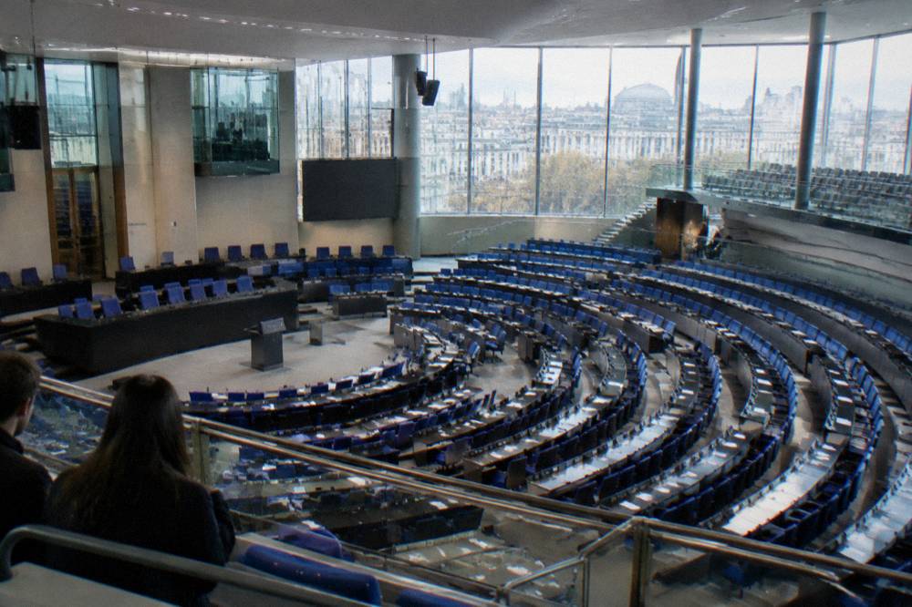 Rows of seats in a parliament debating chamber seen from a public gallery