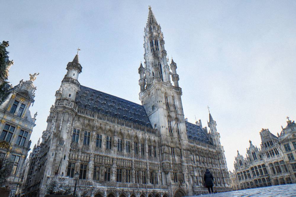 The gothic Town Hall tower of Grand-Place seen from the cobblestones below
