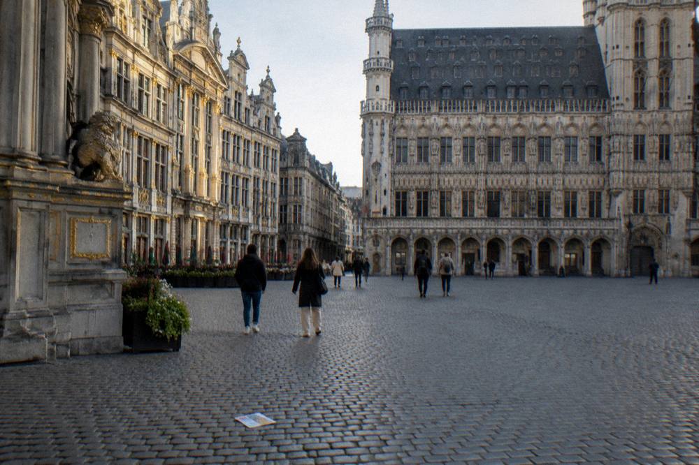 Visitors walking across the open square toward the museum buildings on the far side