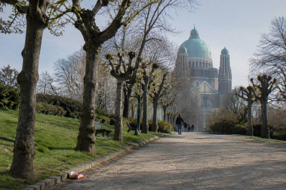Tree-lined paths of Parc Elisabeth with the basilica dome behind the trees