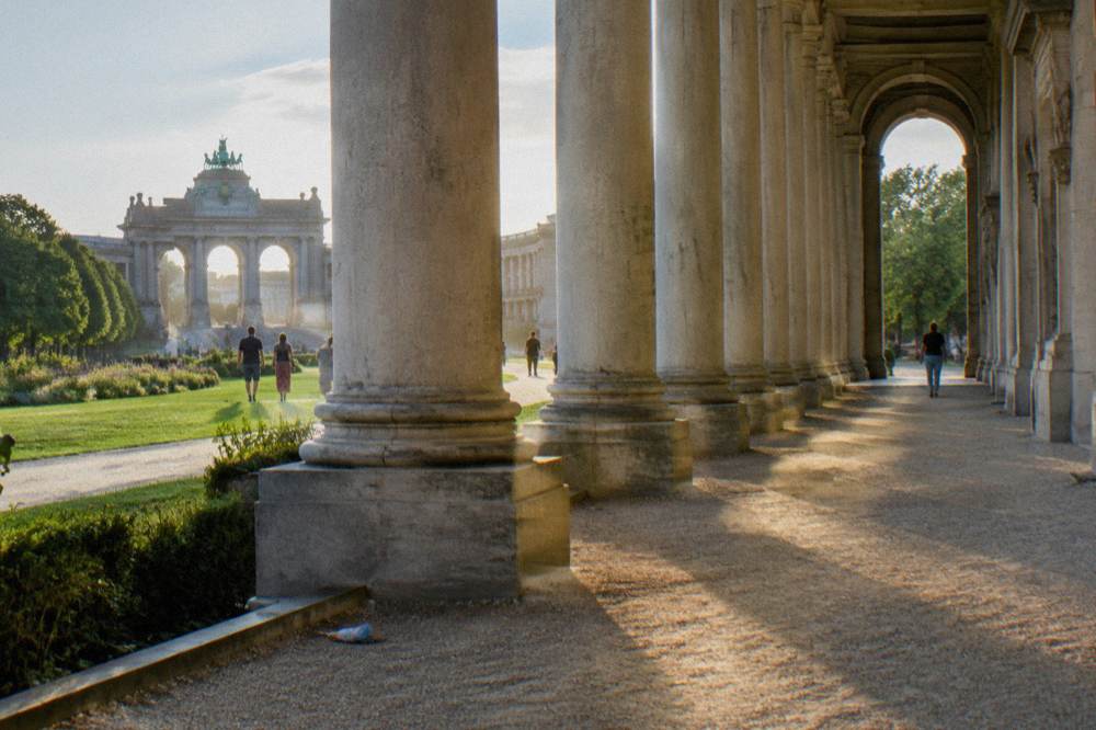 A curved arcade of columns forming part of a monumental park structure under a clear sky