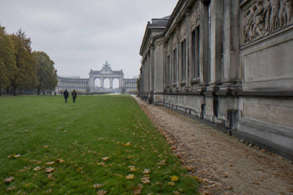 A museum building with a classical facade beside a park lawn under daylight