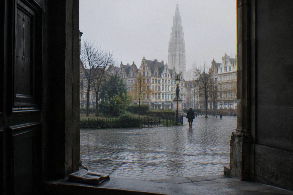 An open square in Brussels with historic facades and a church tower above the rooftops